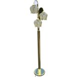 A contemporary brass standard lamp with three flower type shades on adjustable hooked arms,