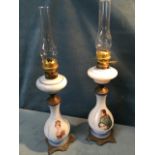 A pair of French glass oil lamps, with Napoleon & Josephine baluster vases beneath bun shaped