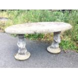A composition stone table with oval top moulded with otters to rim, supportedby a pair of otters