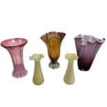 Two glass handkerchief style vases, one purple with opaque white interior, the other amber with
