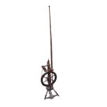 An antique mahogany spinning wheel, the tripod base with treadle mechanism supporting circular bun