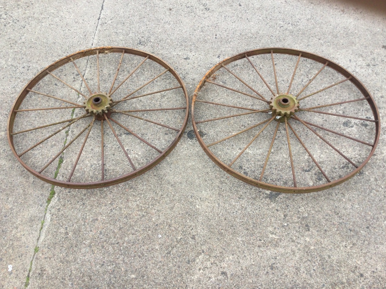 A pair of large agricultural wheels with channelled flat rims framing two sets of spokes with