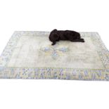 A rectangular Indian Kayam wool rug woven with star shaped floral medallion on pale yellow grid