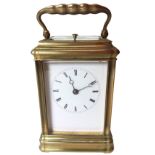 A brass carriage clock by Howell James & Co, the striking working clock in architectural style