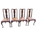 A set of four Queen Anne style mahogany dining chairs with shaped splats above leather drop-in