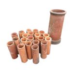 A tapering terracotta chimney pot with moulded rim; and twenty 12in terracotta drainage pipes. (24.