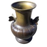 A Japanese bronze vase with ribbed body and waisted neck mounted with two winged moths, raised on