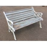 A cast iron bench with wood slatted back & seat, having scrolled ends on channelled sabre legs. (