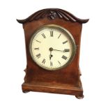 A William IV mahogany table clock having arched case with applied carving and chamfered corners