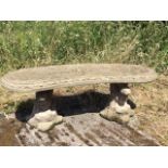A composition stone bench moulded with pair of otters and leaves on naturalistic bases supporting