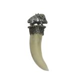 A boars tooth pendant with silver plated boar mount on bead framed platform above pierced collar. (