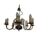 A Dutch style hanging brass chandelier, with column supported by chain from ceiling rose, having bun