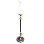 An ebonised and gilt standard lamp, the candlelight on a circular platform with leaf carved gilded