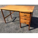 A 1970s rectangular mahogany desk on square column legs, the pedestal to one side with slide above