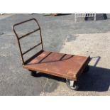 A rectangular flatbed four-wheel trolley by Welconsruct of Birmingham, with tubular handle to