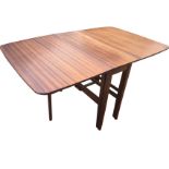 A 60s mahogany dining table with two rounded drop-leaves supported on gate legs, the four column