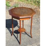 An octagonal walnut lamp table, the moulded top with carved floral medallion, raised on octagonal