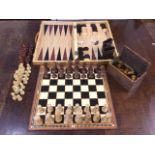 A contemporary inlaid boxed chess/drafts/backgammon set with wood pieces; two other carved wood