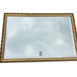 A reproduction gilt framed mirror with bevelled plate in shell & leaf moulded gold frame. (22.5in