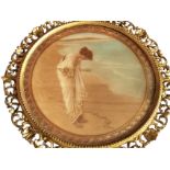 A circular C20th coloured Pre-Raphaelite style print depicting a young lady on a beach with jewel,