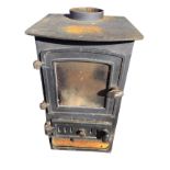 A cast iron cottage stove with back boiler, having bowfronted top and an arched glazed door with