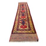 A Turkish wool runner woven with bright field of stylised red serrated flowers on pale yellow