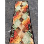 A 50s stylised Axminster style runner, woven with geometric designs within a black border. (27in x