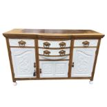 A painted late Victorian carved oak bowfronted sideboard, the rectangular moulded top above two