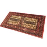 An oriental style rug woven with two panels of twin fretwork grids within linked scrolled borders,