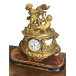 A large Victorian ormolu mantleclock surmounted by putti and goat above a D shaped plinth with
