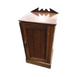 A late Victorian walnut pot cupboard with pediment style upstand on chamfered top, above a grooved