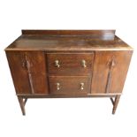 A George VI oak sideboard with rectangular moulded top above two central drawers flanked by