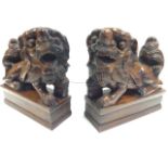 A pair of carved Victorian mahogany book-end with dogs of fo animals on rectangular block