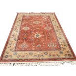 An oriental style rug woven in the Keshan style with field of linked flowers & foliage on pink