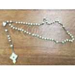 A carved bone set of rosary beads, the cross pendant containing a Stanhope with six Artois views. (