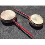 A pair of oriental drums, the circular twin skin sided cushion shaped instruments on tapering carved