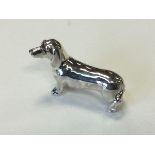 A solid silver daschund inlaid with glass eyes – 925 marks. (2in)