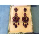 A cased pair of Victorian garnet drop earrings, with circular flowerheads above swagged panels,