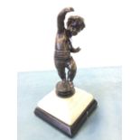 A nineteenth century bronze cherub with black patination, the boy with raised hand standing on