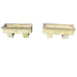 A pair of rectangular composition stone garden planters of brick moulded form on similar stands,