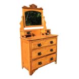 A late Victorian satin walnut dressing table, the arched bevelled mirror with carved crest on shaped