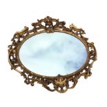 A large nineteenth century carved oval giltwood mirror, the plate on lozenge moulded flowerhead