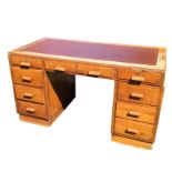 A 1930s oak office desk, the rectangular top inset with leatherette writing surface above three