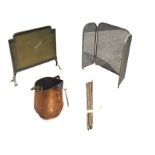 A set of 16 brass stair rods; a copper coal skuttle with brass swing handle; and two mesh fire