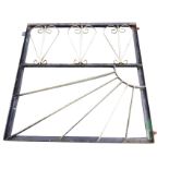 A wrought iron garden gate, the rectangular frame having scrolled decoration to top panel, and