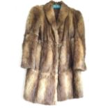 A lined ladies three-quarter length mink fur coat with wide collar.