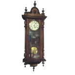 A Victorian mahogany Vienna wallclock, the case with arched pediment mounted with a mask above a
