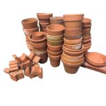 A quantity of terracotta flowerpots and stands. (A lot)