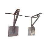 A pair of wrought iron brackets with electric wired connections, having square wallplates and