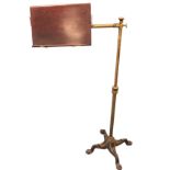 A Victorian music stand by Carters, having brass telescopic column on scrolled quadripartite cast